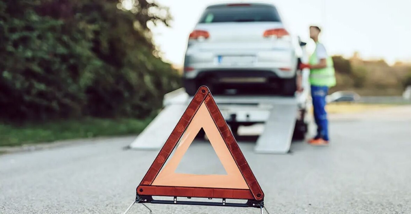 Emergency towing service with warning triangle on roadside in Jurupa Valley