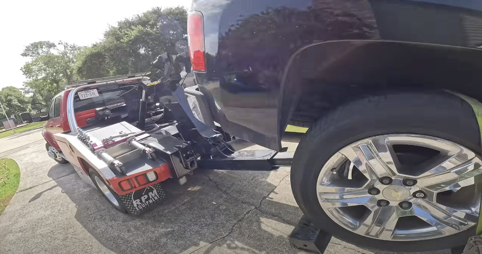 Professional tow truck operator securing a damaged vehicle